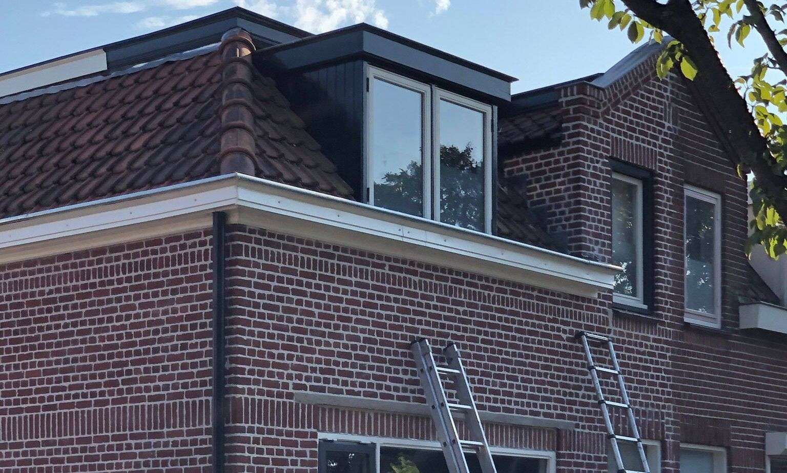 Met de ladden een dakgoot inspecteren in Emmeloord